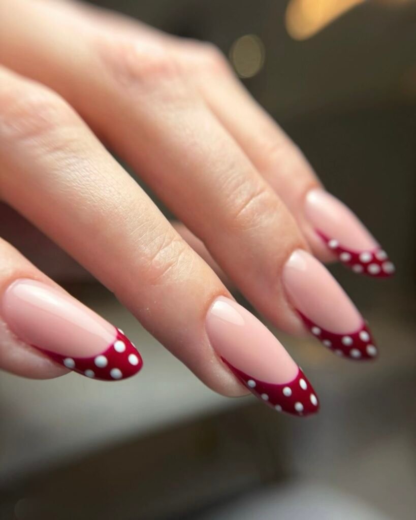 Bordowy french manicure w białe kropki na migdałowych paznokciach